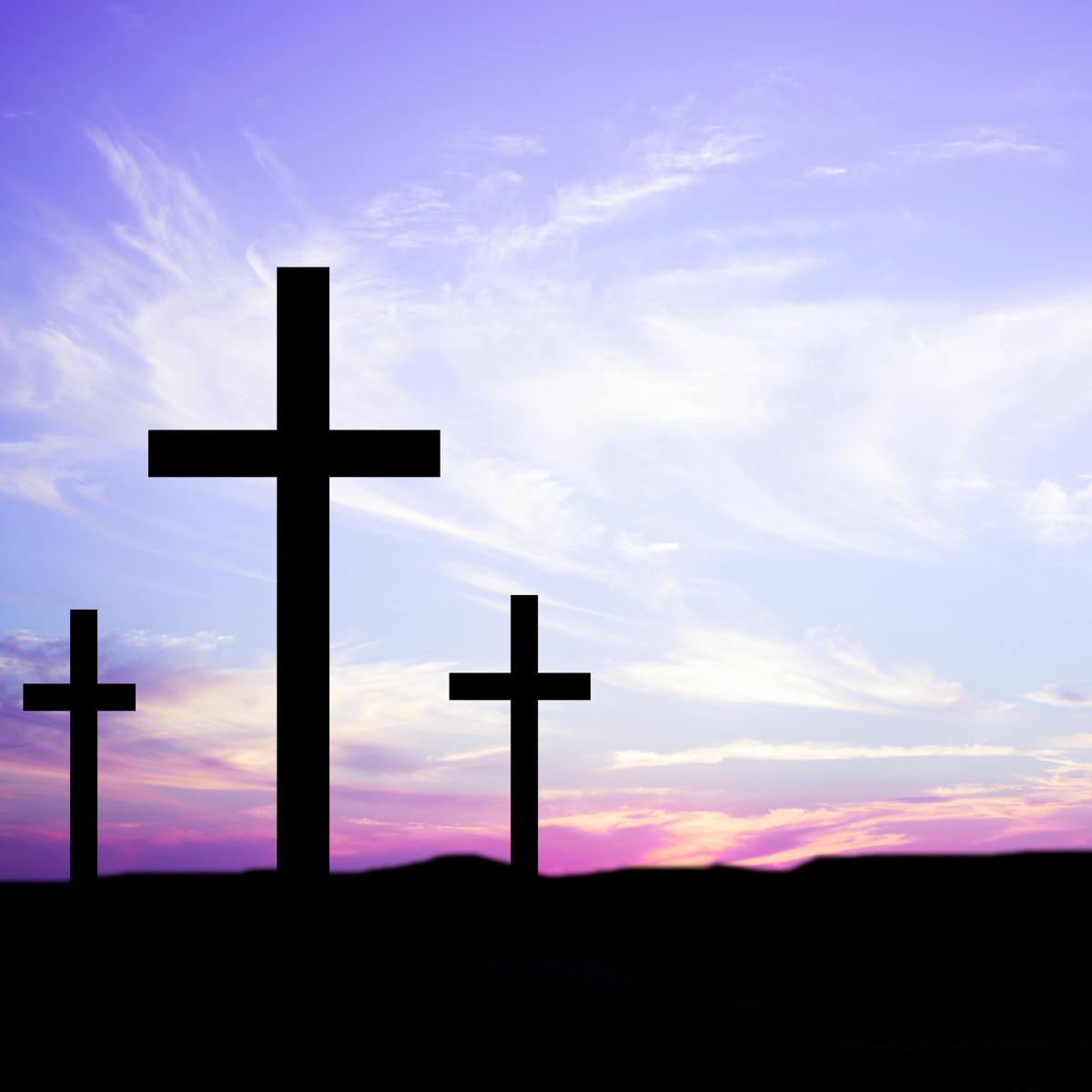 three crosses backlit on a purple sky